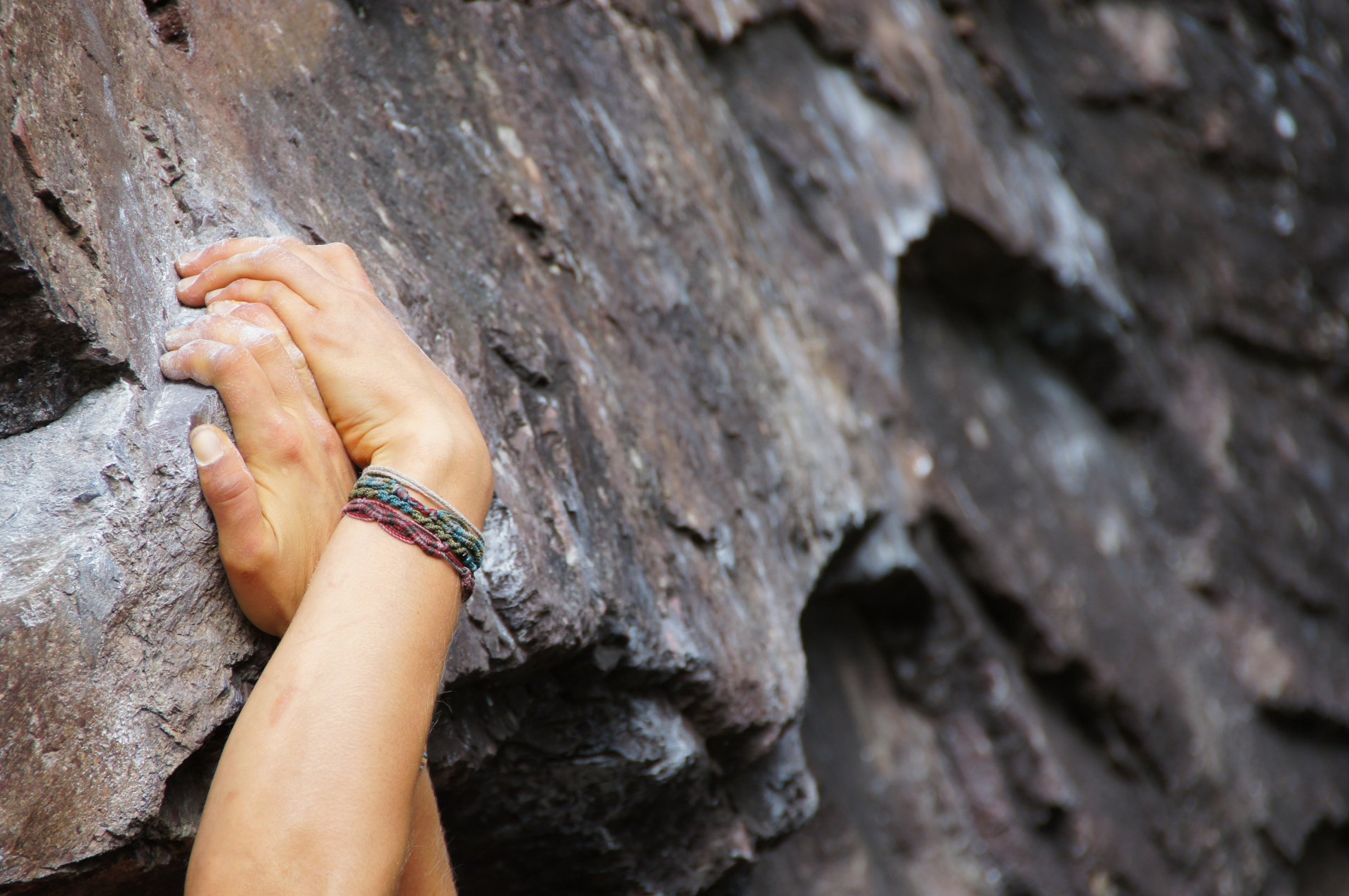 Klettern am Fels. Zwei Kletterhände überkreuzt.